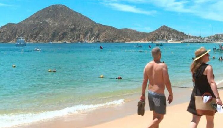Turistas caminando en la Playa El Médano de Cabo San Lucas