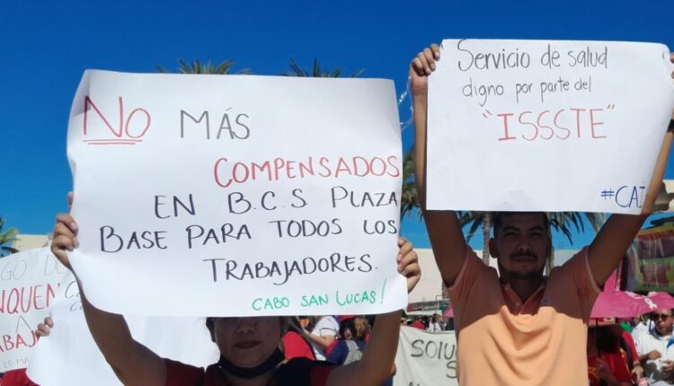 Docentes esperando llegada de AMLO con carteles