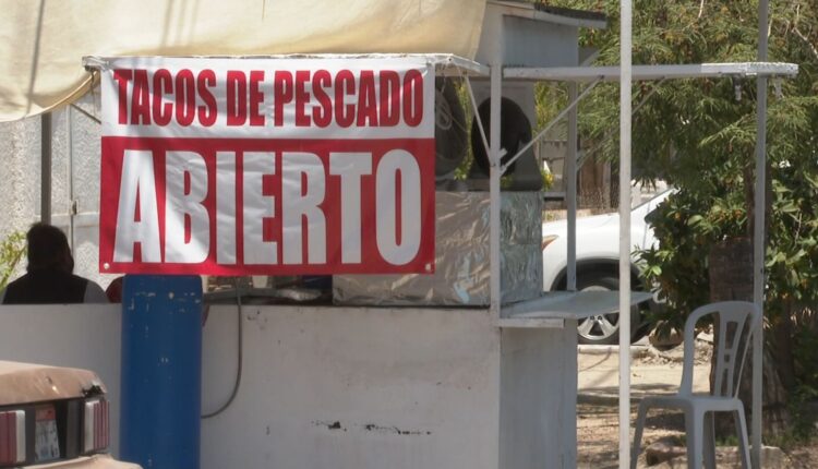 Letrero de puesto callejero de tacos de pescado.