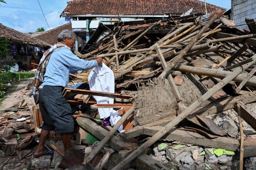 Persona buscando entre los escombros por terremoto de indonesia
