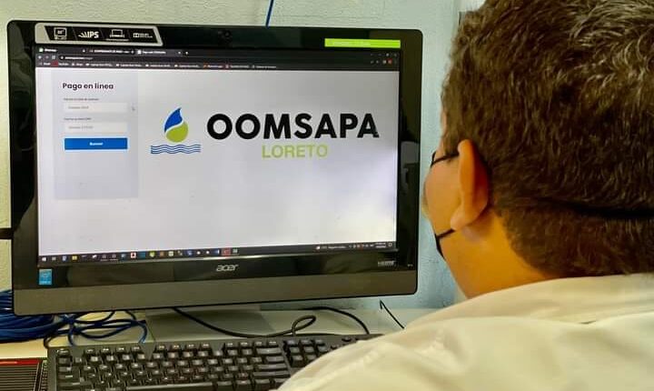 Personal del OOMSAPAS de Loreto frente a computadora en oficinas de la dependencia