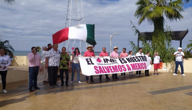 ciudadanos con pancartas para defender al ine