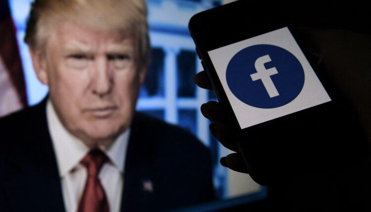 Una pantalla de teléfono muestra un logotipo de Facebook con el retrato oficial del ex presidente de los Estados Unidos Donald Trump en el fondo.