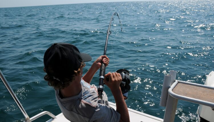 Hombre pescando en un yate.