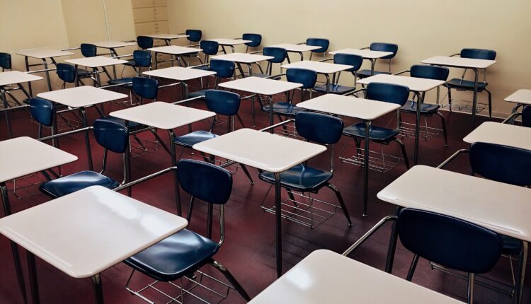 Pupitres vacíos en salón de clases.