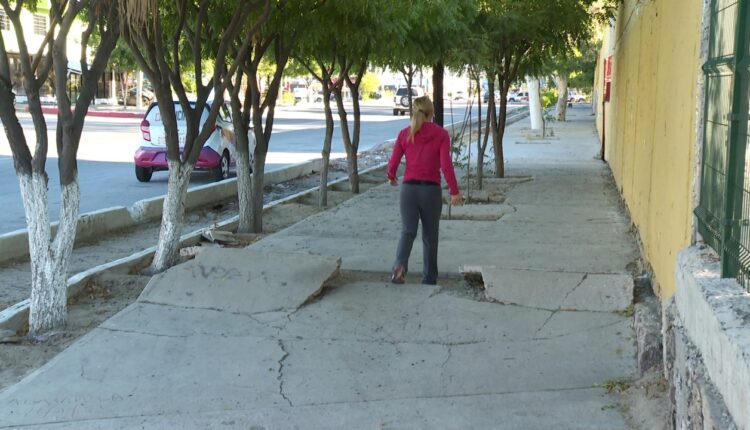 Una mujer caminando en una banqueta