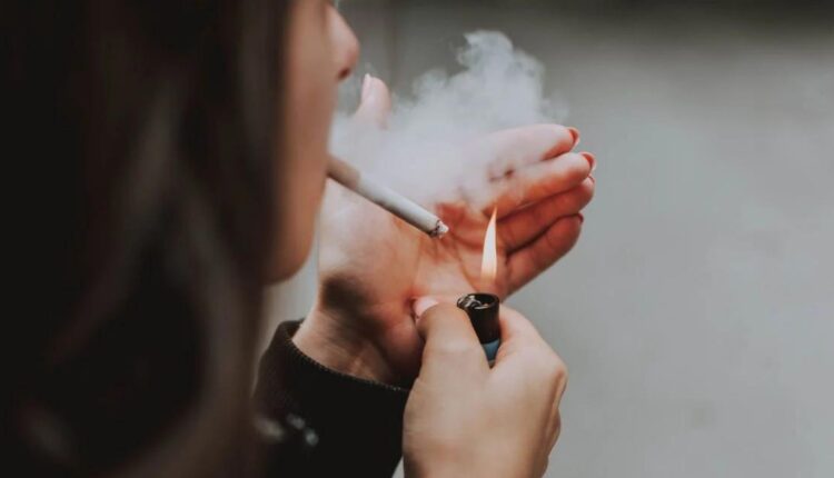 Una mujer prendiendo un cigarro