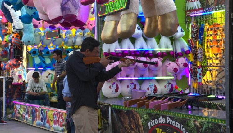 Una persona apuntando con un rifle en un juego de feria