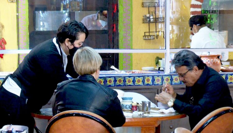 Personas sentadas frente a una mesa en un restaurante