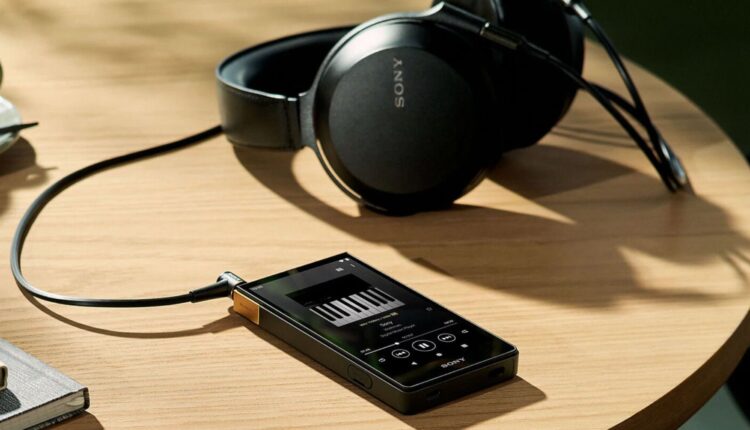El Sony Walkman NW-ZX700 sobre una mesa junto a unos audífonos