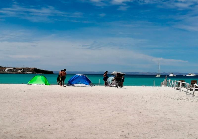 Playa acampando Persisten personas acampando y visitando playas